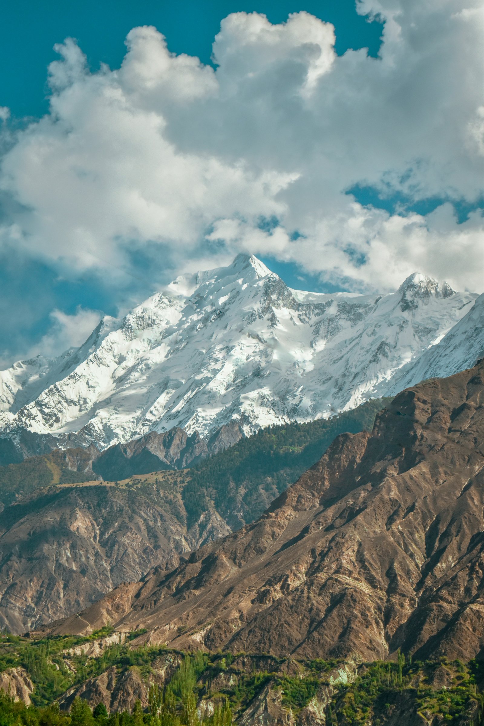 Terraced orchards in bloom below the snow-capped Karakoram range in Hunza, Gilgit-Baltistan